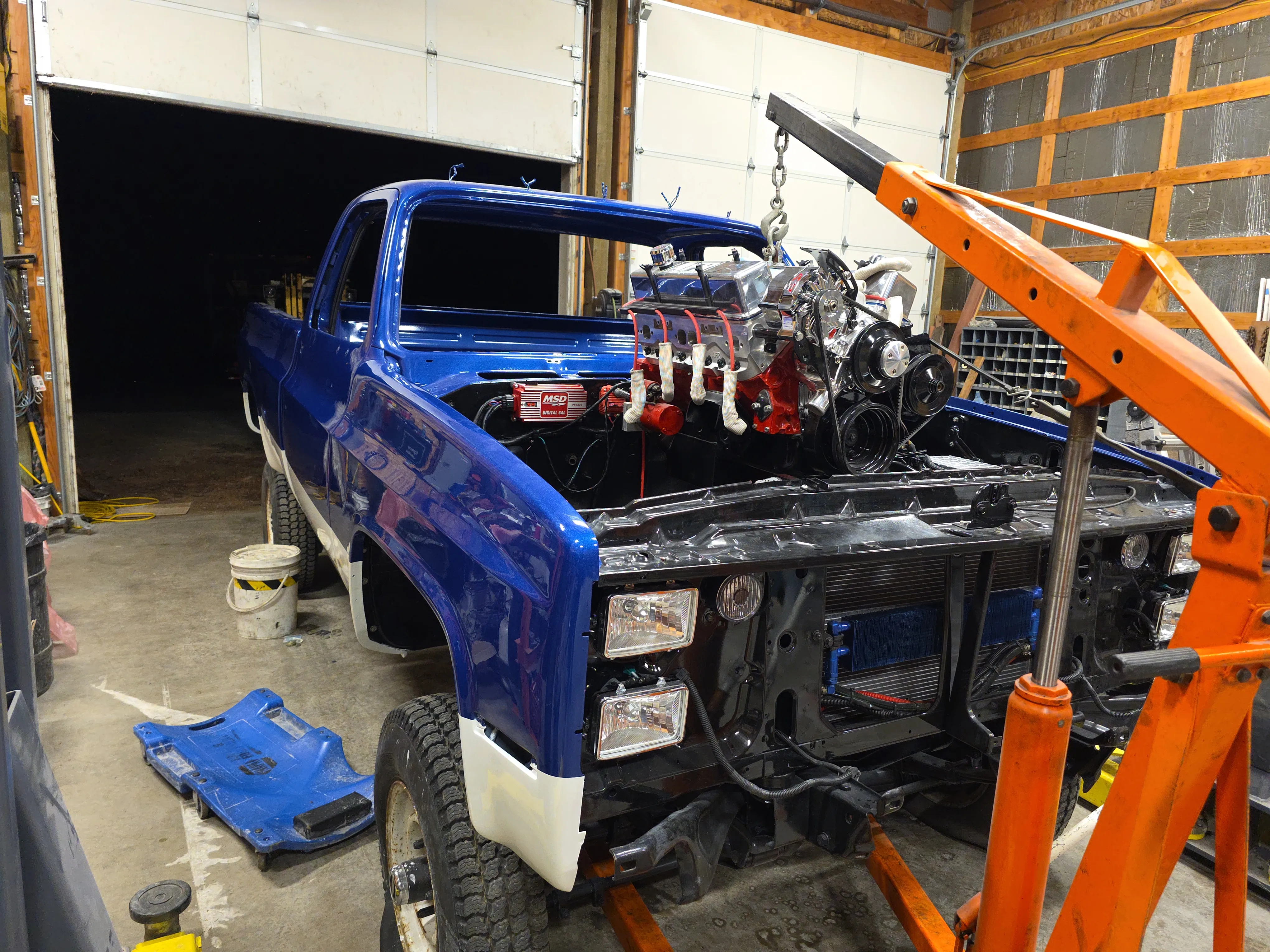 A V8 engine bay during a custom build with fresh manifold and ignition installed